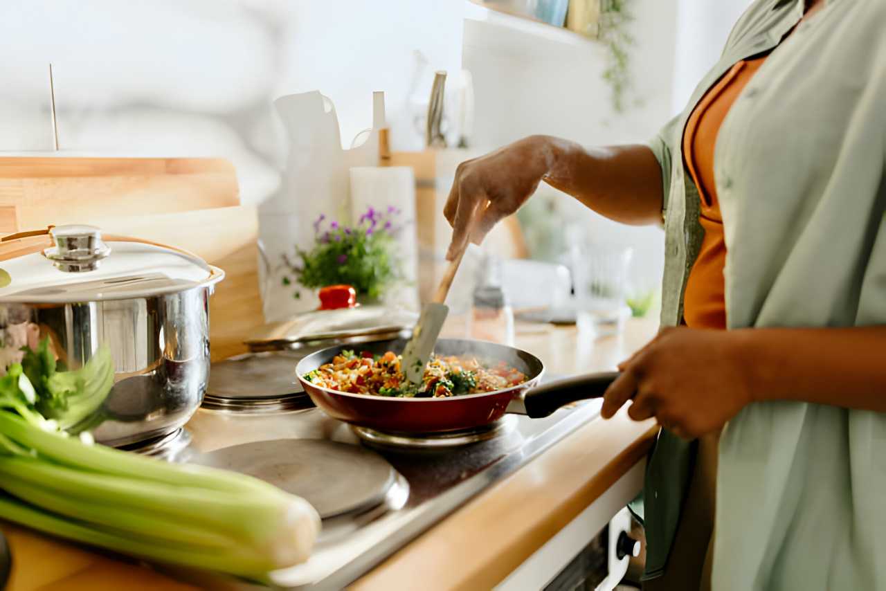Femme préparant un mélange de légumes de quinoa cuit dans une poêle